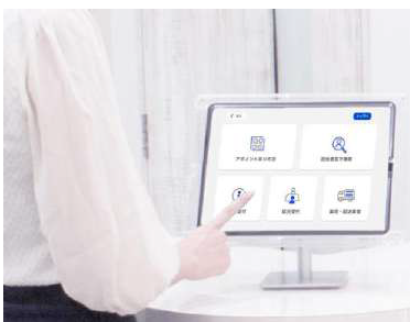 iPadに表示されたラクネコ受付メニューを来訪者がタップ操作
