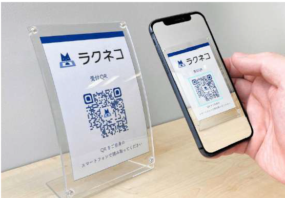 ラクネコQR受付スタンドをスマートフォンで読み取る様子